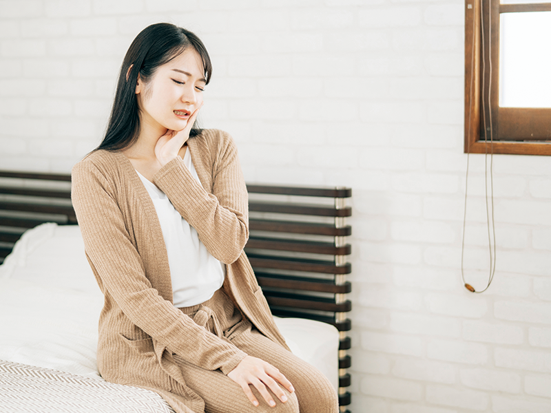 頬を抑える女性
